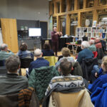 Het publiek kijkt in het Duurzaamheidscentrum naar de informatieavond gegeven door energiecoaches Peter Alkemade en Ton Holtslag